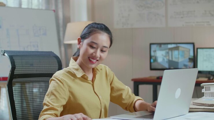 Asian Woman Engineer With A Laptop Drawing Blueprint On The Whiteboard At The Office