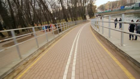 ciclismo en el camino para bicicletas a lo largo del terraplén en el parque de la ciudad. ciclismo de velocidad