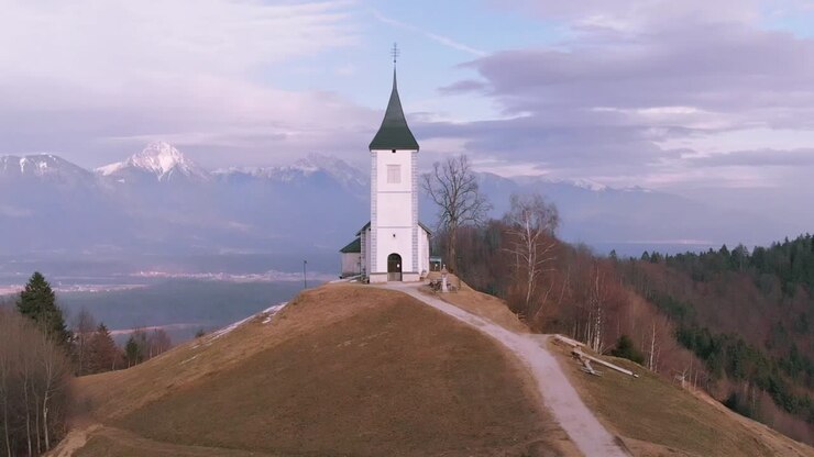 Dolly effect - zoom of the road to the church on the meadow hill