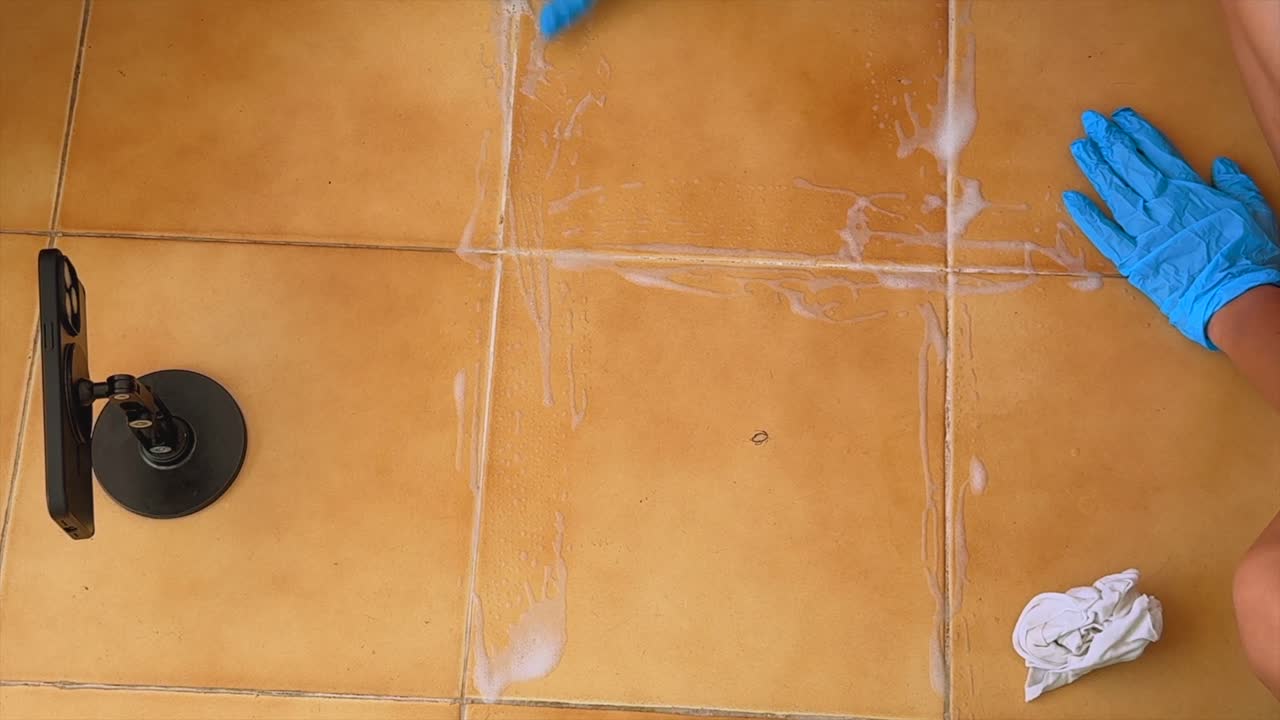 Cleaning Tiled Floor with Foam and Gloves