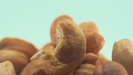 a macro close up shot of a roasted salty cashew bawl on a rotating stand, slow motion, 4k, studio lighting