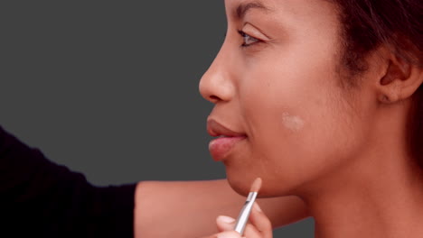 make up artist putting foundation on models face