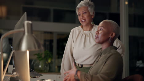 two businesswomen discussing work in an office