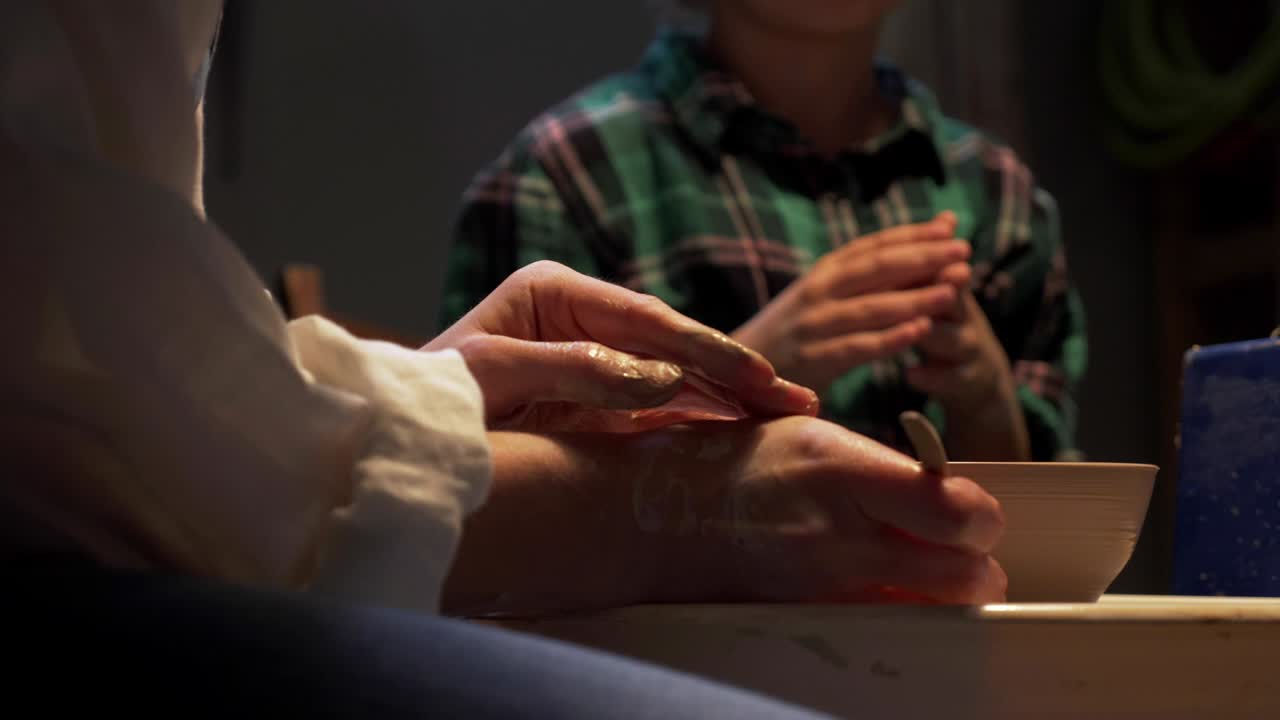 한 여자 가 도자기 바 에 접시 를 조각 하고 있다