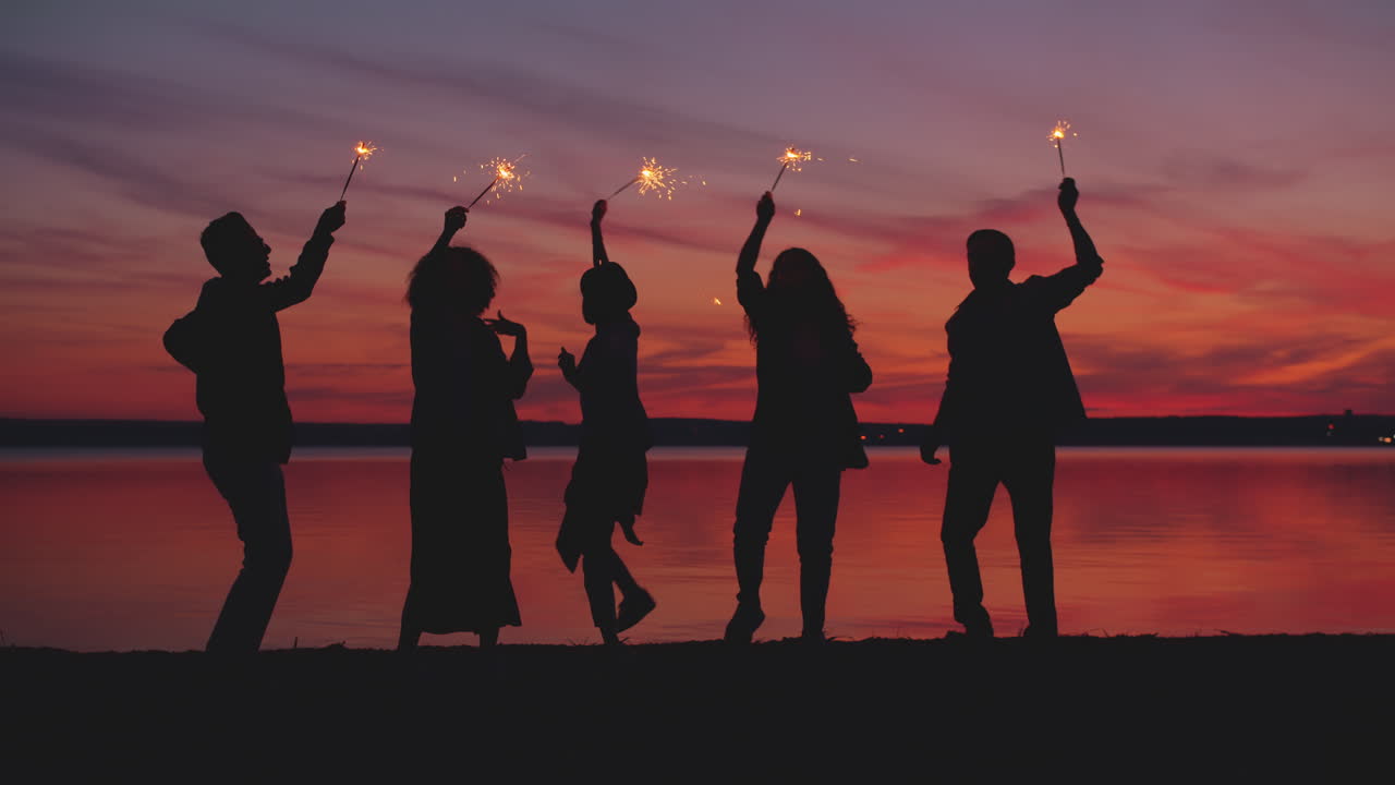 Friends Celebrating Sunset by the Lake with Sparklers