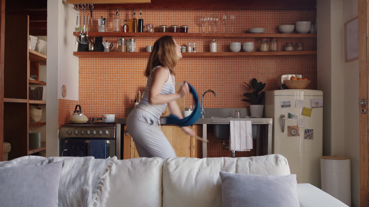 행복한 젊은 여성이 부 ⁇ 에서 춤을 추고 성공적인 라이프 스타일을 축하하고 주말에 집에서 즐거운 승리 춤 축하를 즐기고 있습니다.