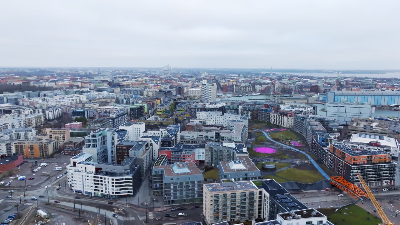 Drone shot rising sideways over the cityscape of Jatkasaari, in cloudy Helsinki