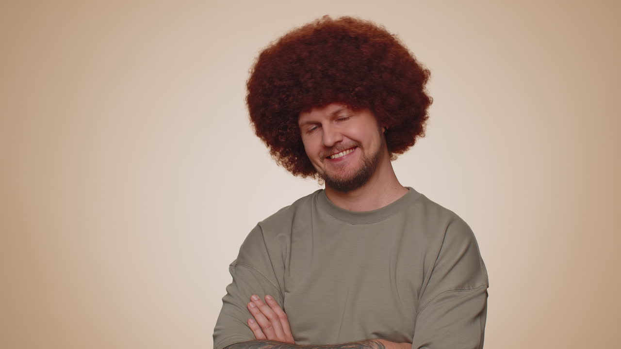 Homem adulto barbudo, modelo de moda, alegre e simpático, de camiseta, sorrindo e olhando para a câmera, sozinho