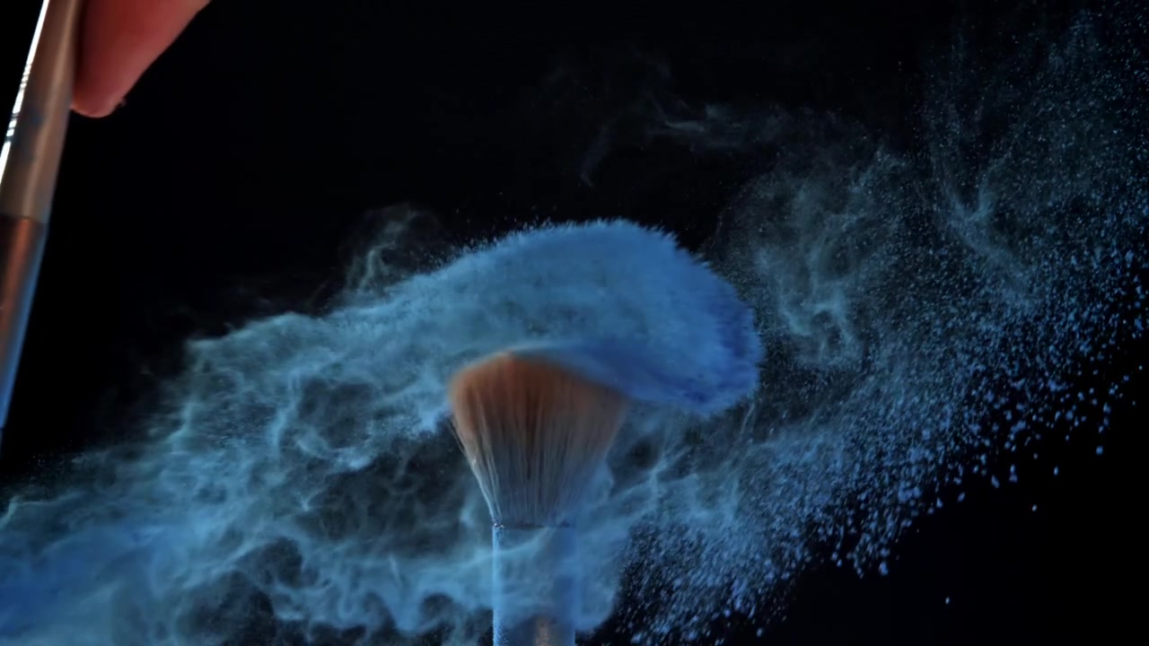 Blue Cosmetic Powder Exploding from Makeup Brush in Slow Motion