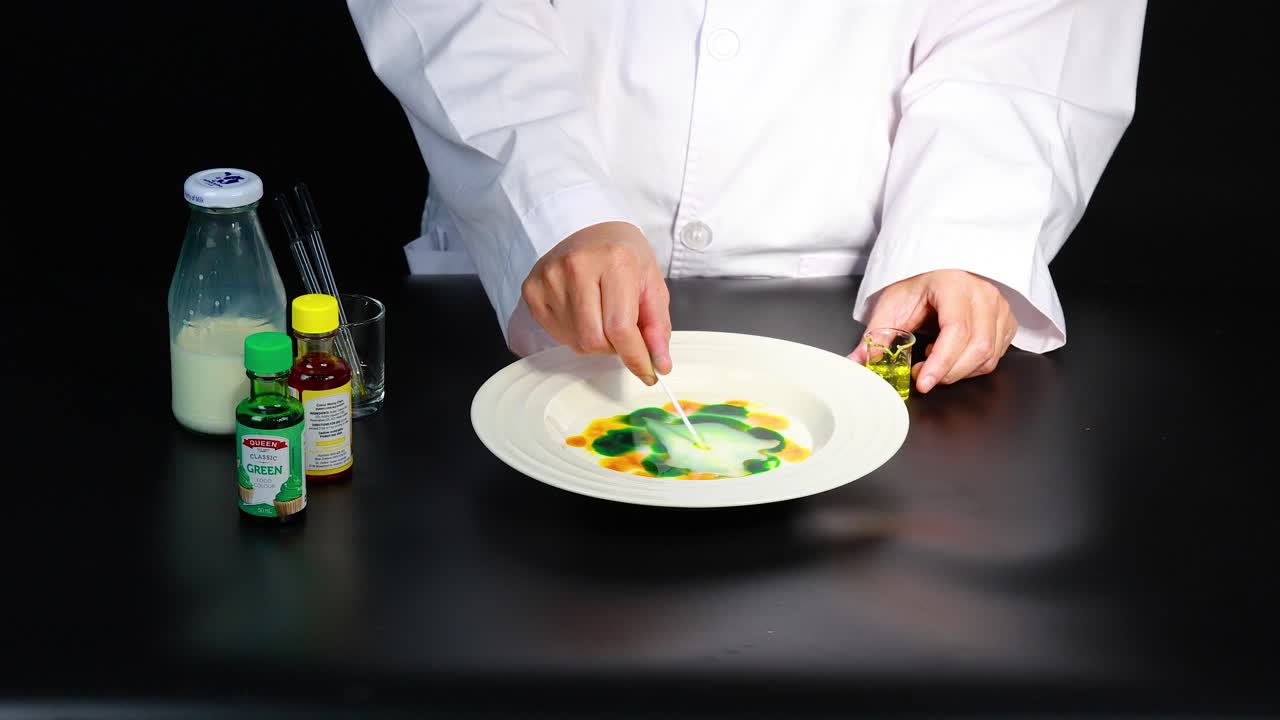 un científico demuestra una reacción de color vibrante en la leche usando colorante alimentario y jabón para platos