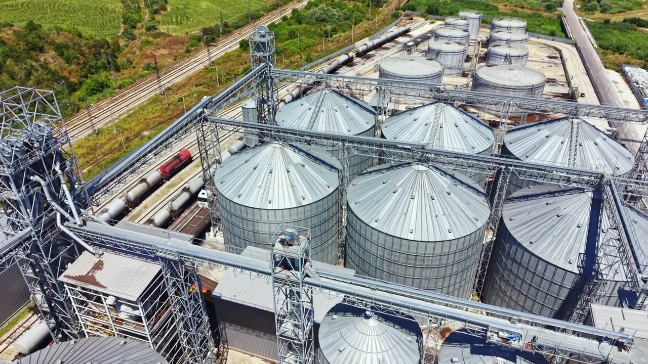 Construction and operation of storage silos at an industrial site near the railway tracks on a sunny day