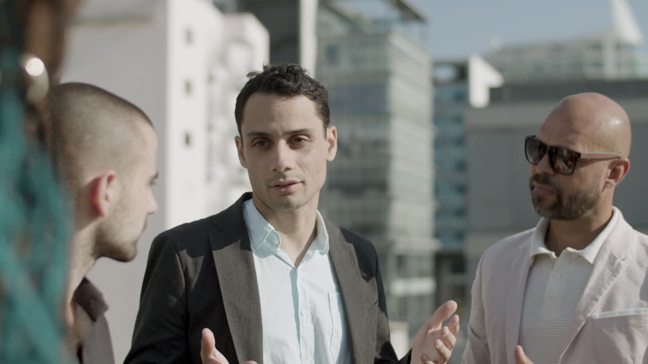 옥상에 서서 이야기하는 비즈니스 파트너의 중간 샷