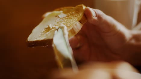 person spreading butter on toast