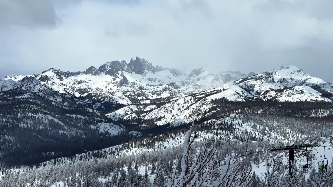 The Hemlocks Mammoth Mountain ski resort California winter spring blizzard deep powder snow Minarets jagged peaks vista view chairlift fog foggy gray clouds mystical sun pan left motion