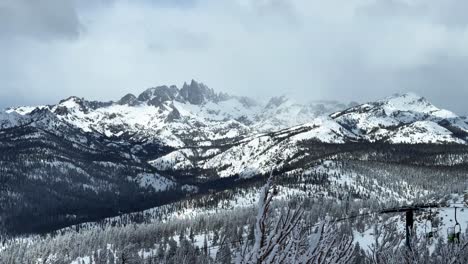 the hemlocks mammoth mountain ski resort california winter spring blizzard deep powder snow minarets jagged peaks vista view chairlift fog foggy gray clouds mystical sun pan left motion