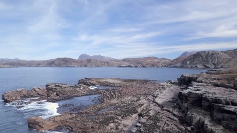 Aerial-footage-of-the-coastline-looking-towards-Loch-Garvie-on-a-sunny-day,-Scottish-Highlands,-Scotland