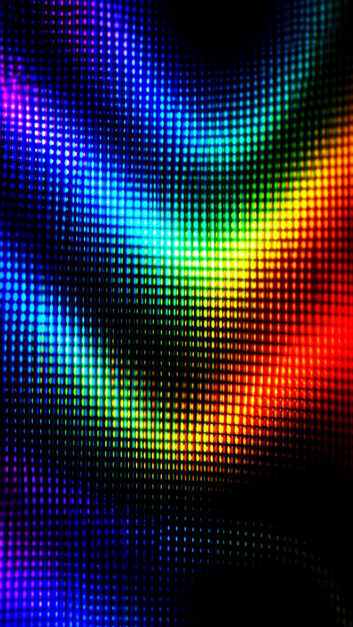 Una vista ravvicinata mostra luci quadrate luminose che formano archi ondulati a strati che cambiano sottilmente posizione nel tempo, creando un vivido motivo arcobaleno con profondi spazi neri e un movimento delicato