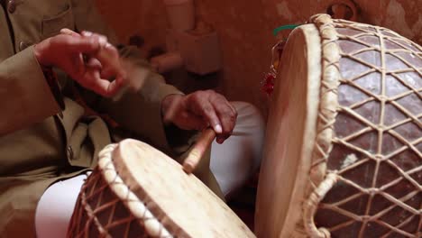 rajasthan, indian. drummer playing traditional indian instrument in the street.