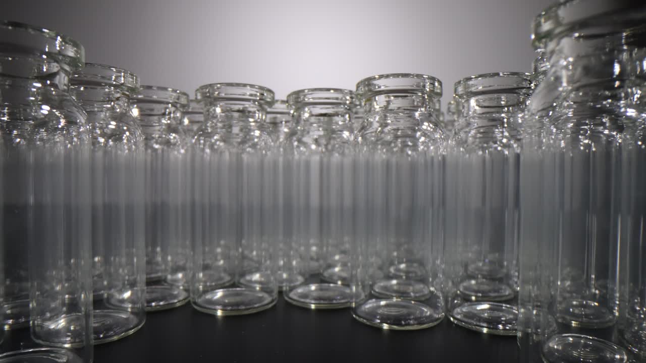 A close-up view of multiple empty glass vials arranged in a semicircular pattern