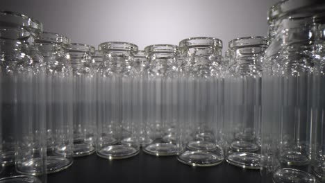 a close-up view of multiple empty glass vials arranged in a semicircular pattern