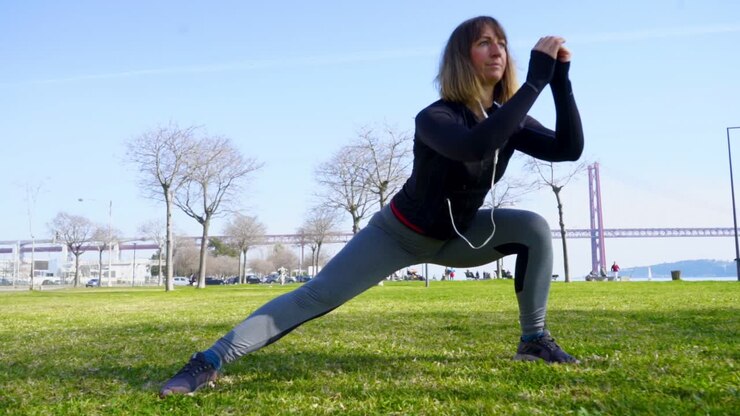 Athletic girl in sportswear working out in park