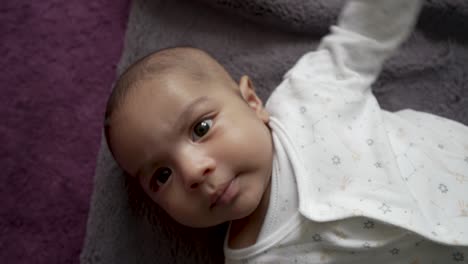 Cute-2-Month-Old-Indian-Baby-Boy-Laying-On-Blanket-On-Floor-Being-Tickled-By-Hands