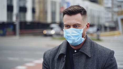 facial portrait of a man in protective mask. young handsome man on blur city background. close-up. concept of health and safety life.