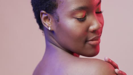 african american woman with short dark hair in blue and pink light, slow motion