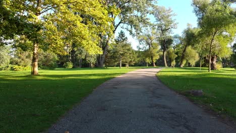 stabilized pov shot walking on footpath at an empty park on a beautiful day, tranquil scene, nature background