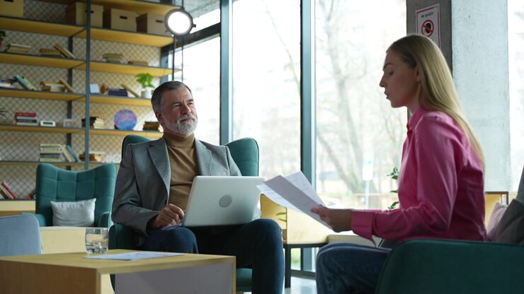Professional Business Meeting Between Mature Man and Young Woman in Modern Office