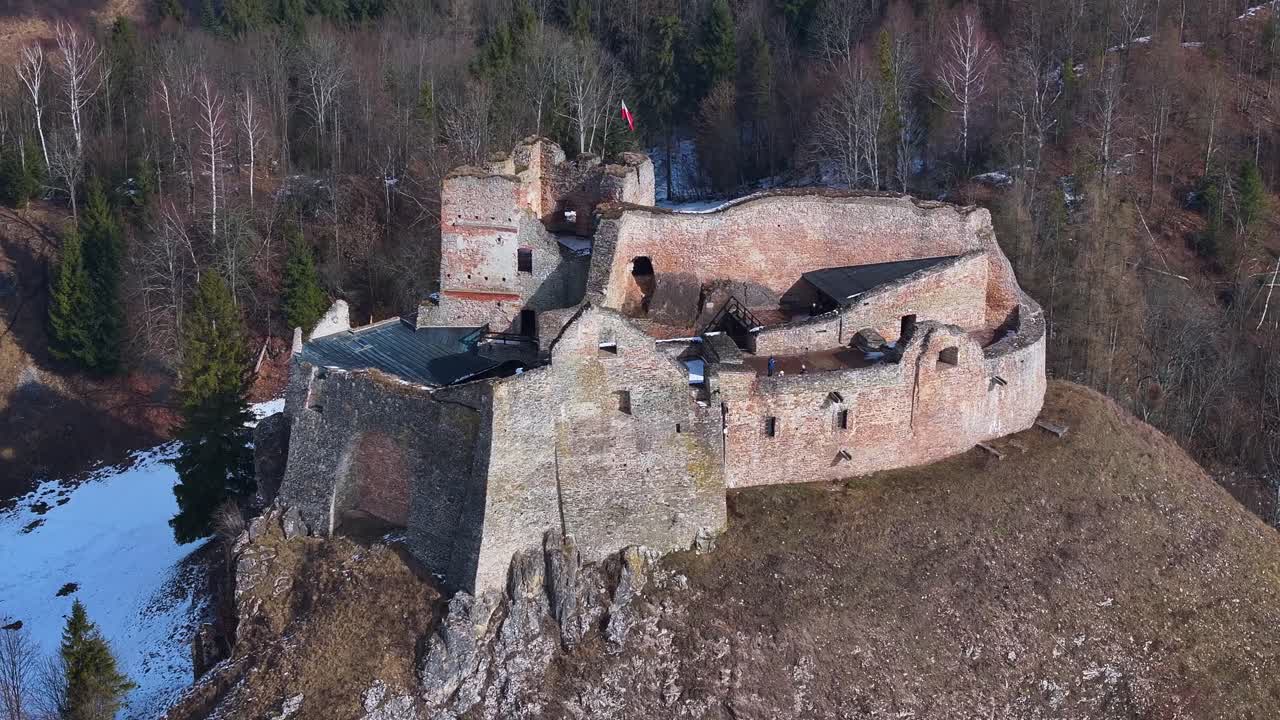 Historické prozkoumávání středověké pevnosti v zimní krajině se sněhovou pokrývkou.