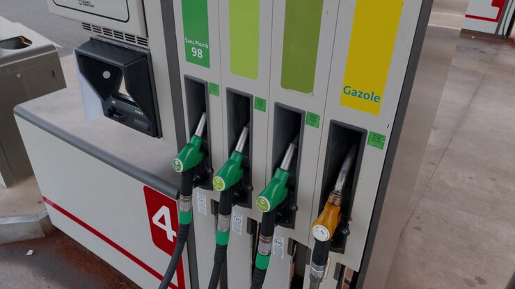 Multiple fuel pump nozzles at a French petrol station, showing fuel type options