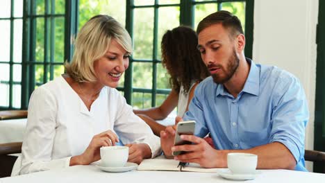 male and female executives discussing over mobile phone 4k