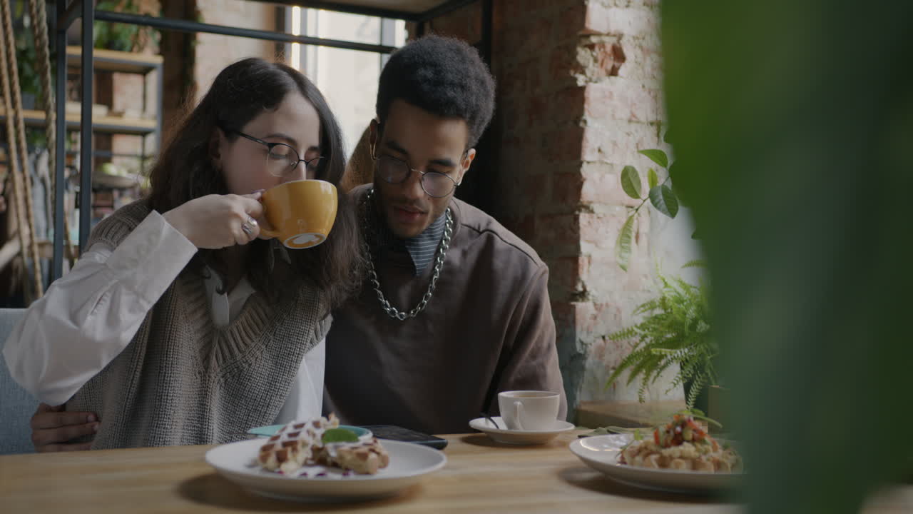 Couple enjoying coffee and waffles in a cafe