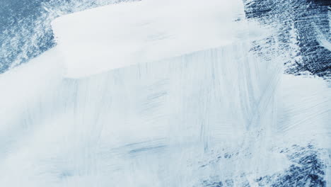 close up of white paint shapes on black background with copy space, slow motion