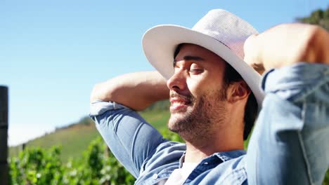 Male-farmer-relaxing-with-hands-behind-back-at-a-vineyard