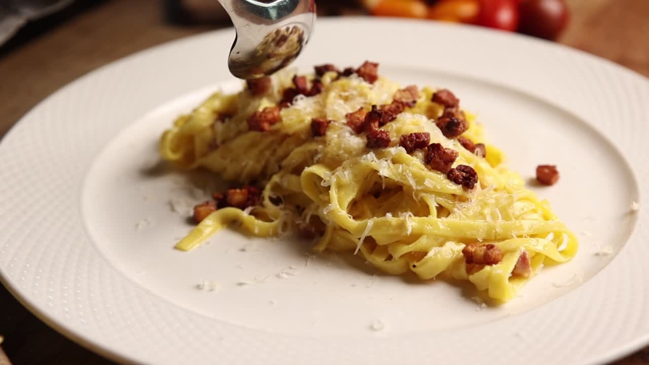 Deliziosa Pasta Carbonara con pancetta croccante e formaggio grattugiato
