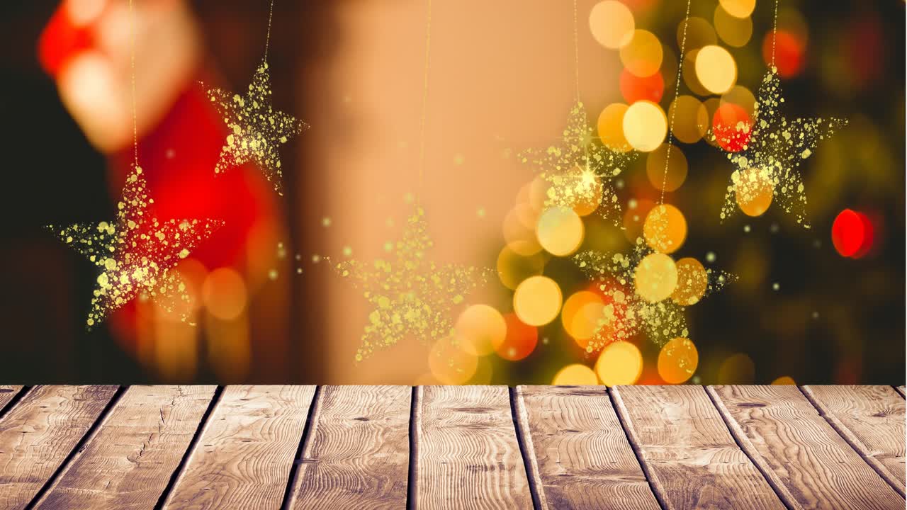 Animación de estrellas de Navidad doradas balanceándose sobre luces de Navidad rojas y amarillas desenfocadas en un árbol.