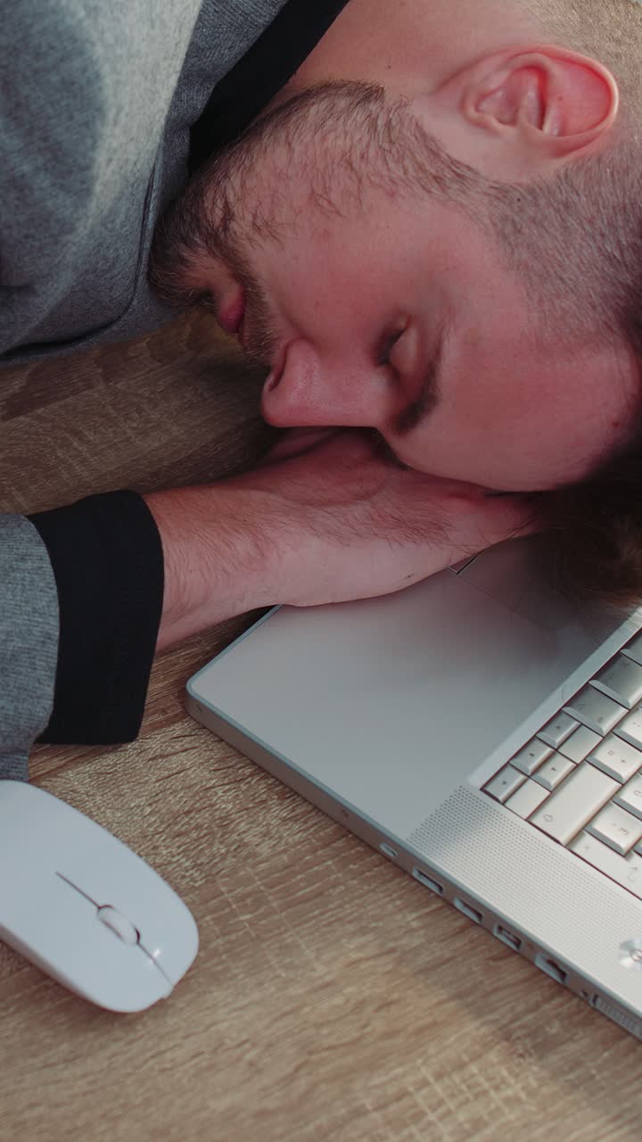 Uomo d'affari annoiato, stanco, addormentato che si addormenta dopo il lavoro di routine sul portatile alla scrivania dell'ufficio