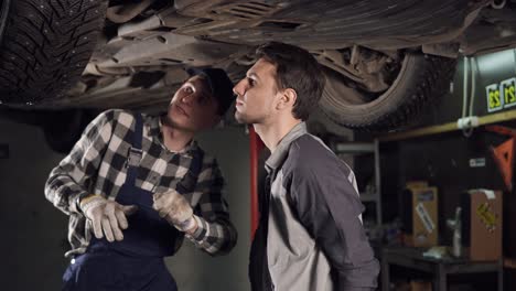 Mechanic-and-his-male-client-checking-out-the-repaired-veicle.-Customer-shakes-hands-with-auto-repair-service-represantative.