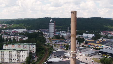 Wohngebäude-Und-Riesiger-Industrieschornstein-In-Der-Schwedischen-Stadt,-Luftdrohnenansicht