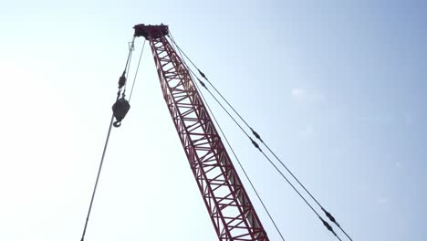 looking at at construction jib section with hanging trolley and hook against clear sunny skies