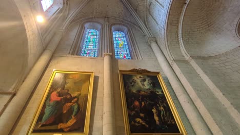 ultra wide view of interior of religious catholic church with stained glass windows with old framed paintings 4k