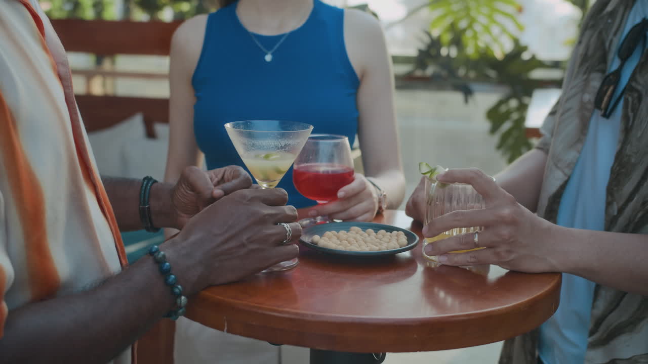 Biracial Colleagues Celebrating Promotion with Cocktails in Bar
