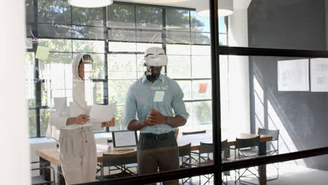 collaborating on project, colleagues writing on glass board in modern office space