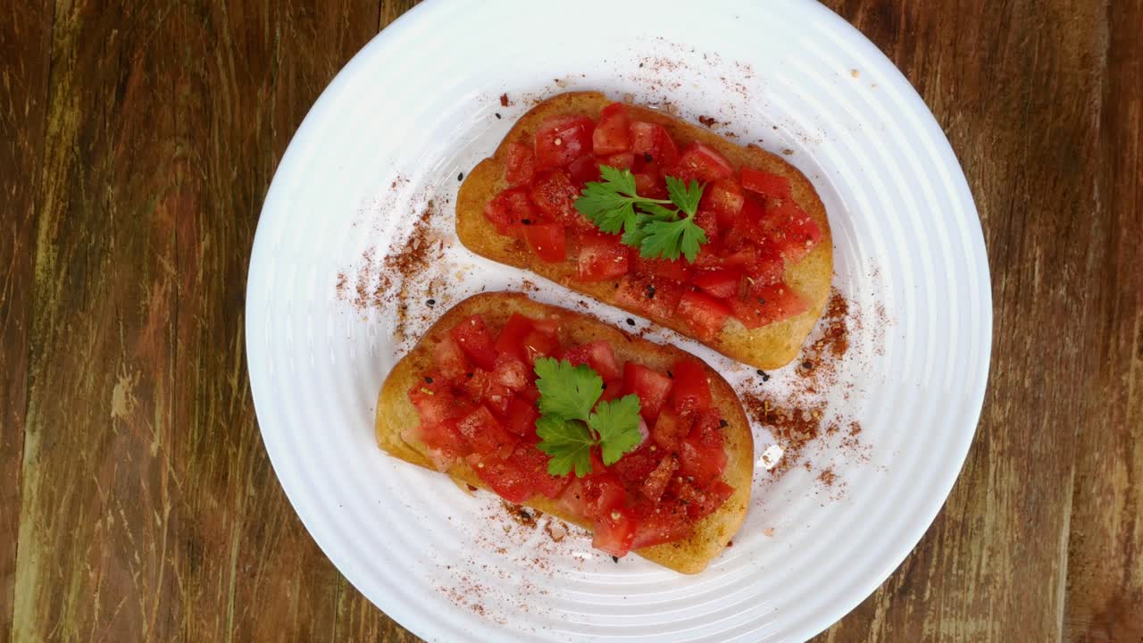 Sanduíche de tomate ou bruschetta italiana com salsa gira lentamente em prato giratório branco. Comida mediterrânea