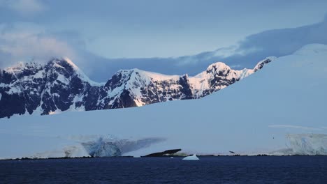 Dramatic-Winter-Mountains-at-Sunset-in-Antarctica-with-Snowy-Snow-Covered-Scenery,-Big-Mountains-in-Cold-Weather,-Antarctic-Peninsula-Coastal-Landscape-on-Beautiful-Coast-Coastline