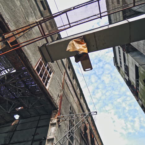 the ruins of an old factory. the abandoned building was covered with grass and trees. holes and cracked in the walls and ceiling. reinforced concrete and brick construction collapse.