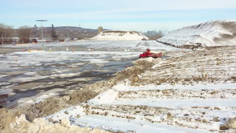 Rotes-Winterdienstfahrzeug,-Das-Schnee-Nach-Der-Entfernung-In-Der-Nähe-Eines-Bulldozers-Ablädt