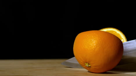 cuchillo cortando la naranja por la mitad